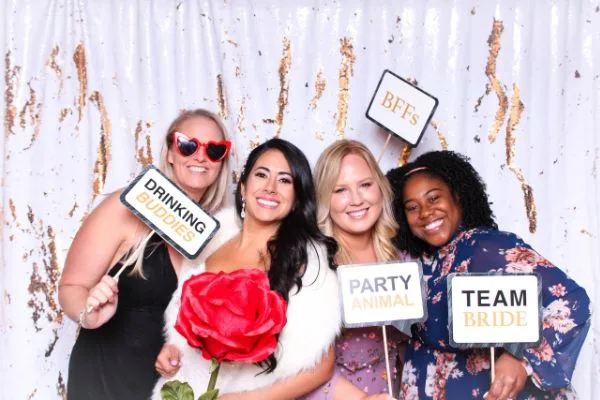 Four smiling guests holding Team Bride, BFFs and Party Animal photo props